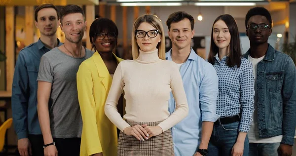 Gülümseyen ve kameraya bakan genç iş adamlarının portresi. Kavramı: uluslararasılık, başlangıç, kariyer, başarı iş, takım.