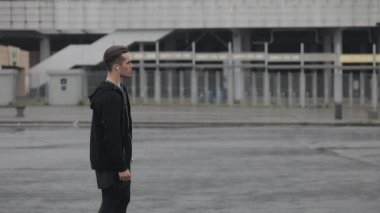 Stadyum arka planda çalışan kulaklıklar ile çekici erkek Runner portresi. Atlet kafasını çevirir ve kameraya bakıyor. Sağlıklı Fitness atletik adam jogging açık havada
