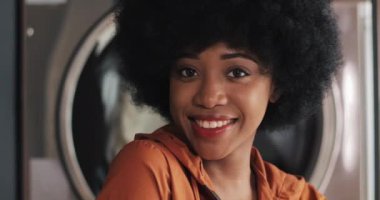 Self-servis kamu çamaşırhaneayakta genç gülümseyen Afrikalı Amerikalı kadın Portresi.