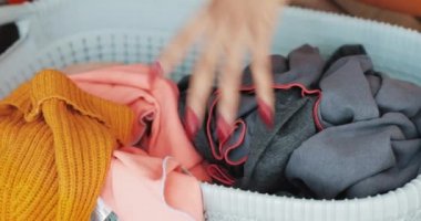 Bir kadın el çamaşır makinesinde yıkamadan önce sepetten kirli giysiler alır. Çamaşır günü.