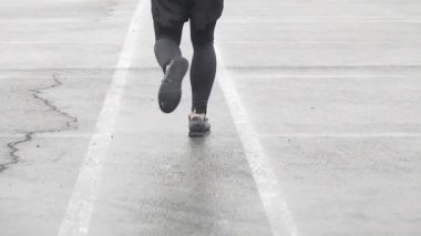 Spor ayakkabıları bir Runner bacaklar yavaş hareket çekim. Erkek spor adam jogging açık havada. Yağmurlu havalarda çalışan tek koşucu. Yakın çekim.