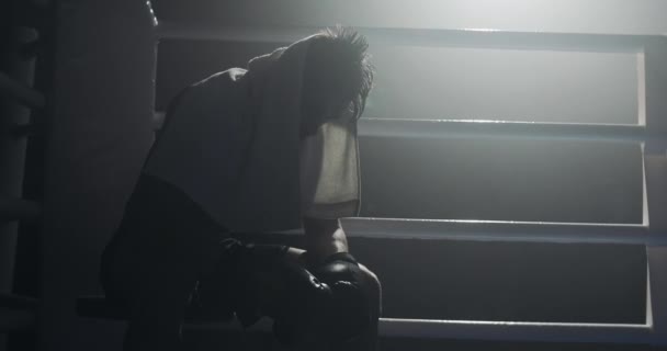 Boxer masculino cansado com um descanso de toalha na borda do anel de boxe. Boxer descansando após o treinamento duro . — Vídeo de Stock