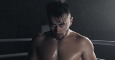 Boks yüzük üzerinde ayakta öfkeli erkek boksör portre ve yoğun kamera bakıyor.