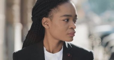 Eski sokak arka planda duran şık Afro-Amerikan iş kadını portresi. Kameraya bakıyor ve gülümsüyor. Siyah Şık. Dreadlocks. Afro Saç Modeli.