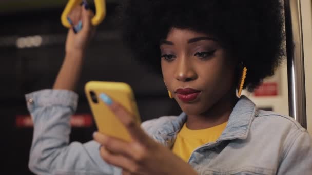 Happy Afro zakenvrouw juichen vieren kijken naar smartphone. Jonge stedelijke professionele succesvolle zakelijke vrouw ontvangen van goed nieuws rijden in het openbaar vervoer. — Stockvideo