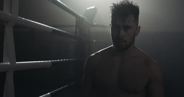 Vermoeide mannelijke bokser staande op de boksring en op zoek naar RHE camera. Close-up. BoKS concept. Silhouet. — Stockvideo