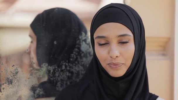 हिजाब हेडस्कारफ पहनने वाली सुंदर युवा मुस्लिम महिला का चित्र पुराने शहर पृष्ठभूमि पर खड़े कैमरा में मुस्कुराते हुए . — स्टॉक वीडियो