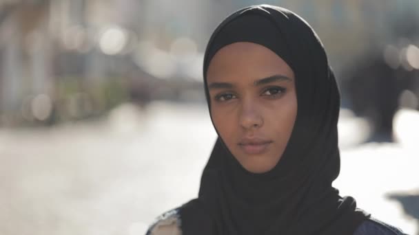 Retrato de bela jovem muçulmana vestindo lenço de cabeça hijab olhando para a câmera em pé no fundo da cidade velha . — Vídeo de Stock