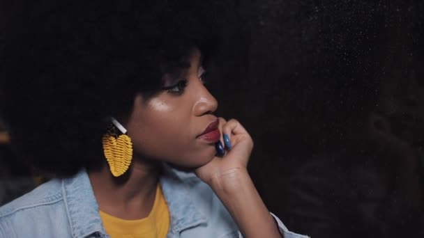 Una giovane donna afroamericana depressa e triste che guida un mezzo di trasporto pubblico di notte. Lei guarda fuori dalla finestra . — Video Stock