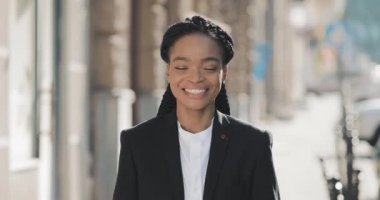 Eski sokak arka planda duran şık Afro-Amerikan iş kadını portresi. Kameraya bakıyor ve gülümsüyor. Siyah Şık. Dreadlocks. Afro Saç Modeli.