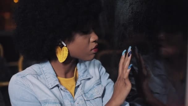 Depressed, sad younf african american woman riding a public transport at night. She looking out the window. — Stock Video