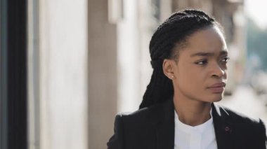Şehirde yürüyen Afro-Amerikan iş kadını üzgün bir yüz. Umutsuzluk içinde çekici bir iş kadını. Eski şehir etrafında üzgün arıyorsunuz.