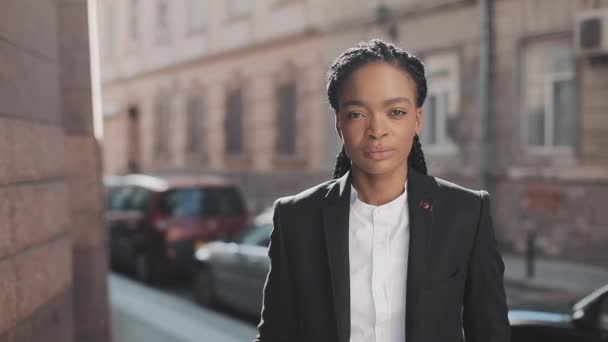 Portrait of stylish afro business woman standing on the old street background. She looking at the camera. Black Stylish. Dreadlocks. Afro Hairstyle. — Stock Video