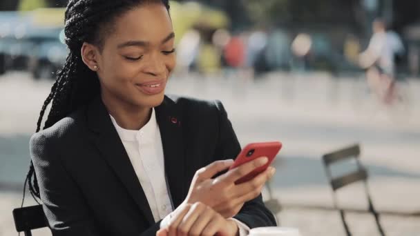 Stijlvolle Afro zakenvrouw het verzenden van Audio Voice bericht op mobiele telefoon bij buiten praten met Mobile Assistant. Business Lady zittend op het zomerterras in gezellig café. Outdoor. — Stockvideo