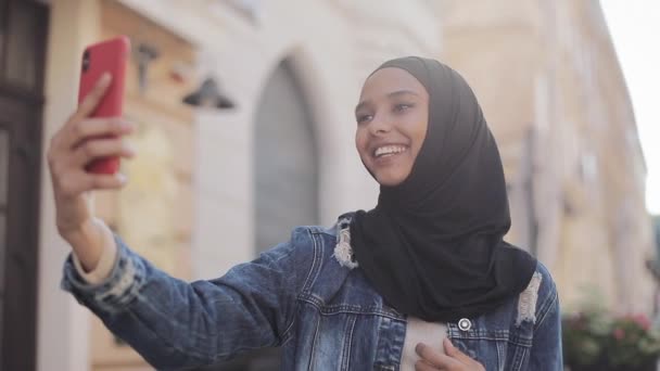 Retrato de jovem muçulmana vestindo hijab tendo chamada de vídeo usando câmera enquanto viaja na cidade beatiful . — Vídeo de Stock