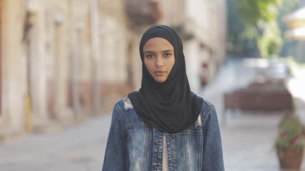 Les femmes résistent au symbole. Jeune femme musulmane portant hijab foulard faire un geste de poing debout sur le vieux fond de la rue . — Video