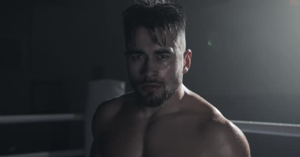 Portrait de boxeur masculin en colère debout sur le ring de boxe et regardant intensément la caméra . — Video