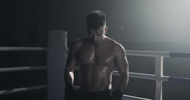 Portret zmęczonego męskiego boksera stojącego na pierścieniu bokserskim i intensywnie spoglądający na kamerę. — Wideo stockowe