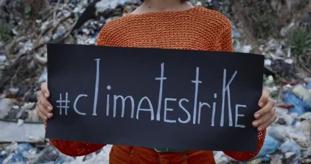 기후 파업 글이 적힌 검정 색 카톤을 키우는 여성의 모습. 쓰레기 언덕 앞에 서서 지구 오염에 항의하는 여성들. 생태계에 대한 인식의 개념. — 비디오