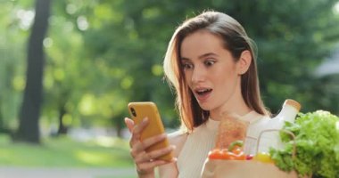 Akıllı telefon kullanırken şaşırmış güzel bir kadının 