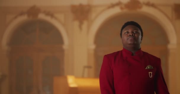 Crop view of gospel performer in red suit standing and singing. Young man performing worship music and moving body in rhytm.Concept of people and religion. Indoors. — Stock Video