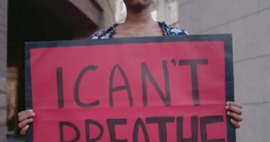 Afro-amerikan kız öğrenci, üzerinde nefesimi tutamıyorum. Milenyum kızı sokakta dikilirken polis şiddeti ve ırkçılığına karşı hareketi destekliyor.