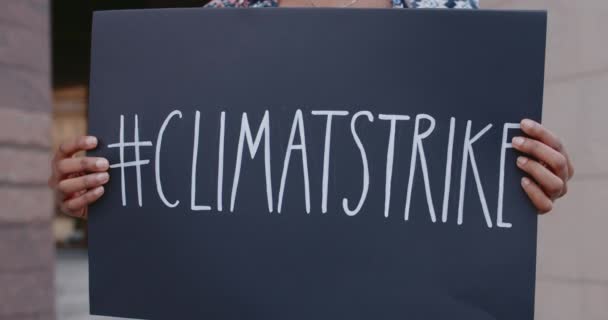 Mani afro-americane con cartello di cartone con hashtag di sciopero del clima sulla City Street. Attivista che colpisce per l'ecologia e il pianeta pulito. Concetto di salvare la Terra. — Video Stock