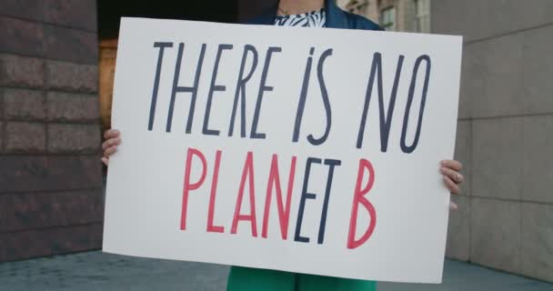 Close up view of female hands holding carton placard with there is no planet b writing. Woman supporting eco movement while doing single protest at city street. Concept of eco. — Stock Video