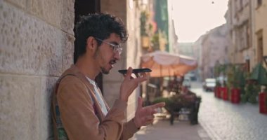 Burun halkalı yakışıklı bir adam duvara yaslanmış dururken hoparlörden konuşuyor ve yazı yazıyor. Milenyum çocuğu internette geziniyor ve Old Street 'te akıllı telefon ses asistanı kullanıyor..