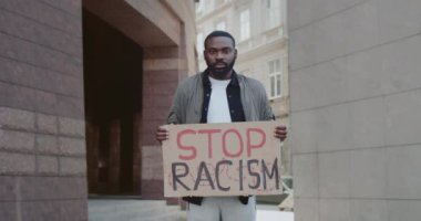 Şehir sokaklarında ırkçılık karşıtı kampanyayı destekleyen Afrikalı Amerikalı bir adam. Elinde karton sakallı bir adam. Eşit insan hakları ve hoşgörü kavramı. Yakınlaştır.