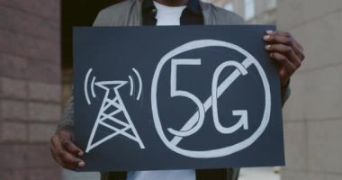 Erkek ellerinin pankart tutarken 5 G işareti olmasın. Afrikalı Amerikalı adam yeni teknolojiye ve uygun anten konuşlanmasına karşı tek bir protesto yapıyor..