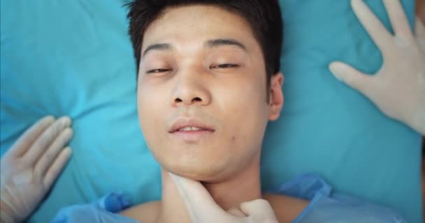 Ovanifrån av ung skadad kille hjärtslag stoppas när han ligger på medicinsk bår. En asiatisk man dör när han åker ambulans till sjukhuset. Begreppet sjukdom och hälsovård. — Stockvideo