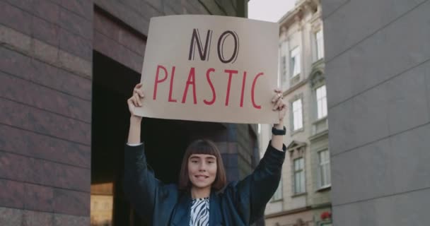 Crop άποψη του κοριτσιού χωρίς πλαστικό χαρτόνι πλακάτ στέκεται στο δρόμο της πόλης και φωνάζοντας. Γυναίκα που υποστηρίζει το κίνημα οικολογίας. Έννοια της περιβαλλοντικής ρύπανσης και να σώσει τη Γη. — Αρχείο Βίντεο