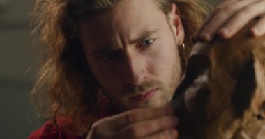 Tutkulu genç heykeltraşın insanların kafasını çömlekçilikten şekillendirmesine yakından bakın. Erkek heykeltıraş, sanatçı stüdyosunda heykel büstü yaparken yüz detaylarını ayarlıyor. Sanat eseri kavramı.