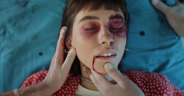Ovanifrån av hipster flicka i blod som går i ambulans. Ambulanspersonalen håller huvudet på en ung kvinna med skador medan hon ligger på sjukhusbår. Begreppet vård och olycksfall. — Stockvideo