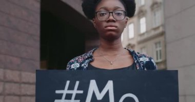 Genç Afro-Amerikan kadının cinsel saldırıya karşı protestoyu desteklemesine yakından bakın. Üzerinde karton levha ve Metoo etiketi olan sıkıntılı bir kız. Sosyal sorun kavramı..