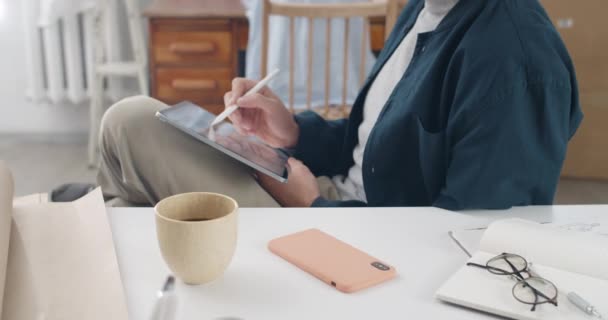 Graancirkel weergave van grafische illustrator houden tablet op knie, terwijl het creëren van zwart-wit beeld. Man tekenen met stylus tijdens het zitten en werken aan het project. Inzoomen.. — Stockvideo