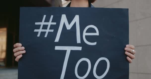 Zamknij widok młodej kobiety z kolczykiem w nosie popierającej protest przeciwko napastowaniu seksualnemu. Dotknięta milenijna dziewczyna stojąca z chorągwią i hasztagiem Metoo na nim.Koncepcja problemu społecznego. — Wideo stockowe