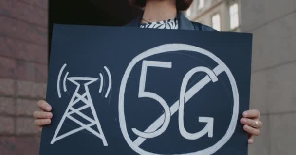 Közelről látjuk a női aktivistát, akinek nincs 5 g-os jele. Hipster nő egyetlen tiltakozás ellen az új technológia és kompatibilis antenna telepítése a város utcájában. — Stock videók