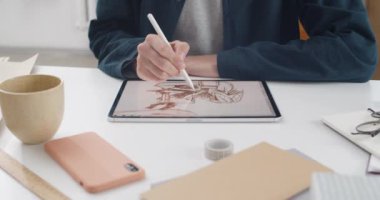 Tablet ekranına resim çizen çizer ellerin kırpma görünümü. Oturup proje üzerinde çalışırken dijital ped ve stil kullanan Talanted grafik tasarımcısı. Kapalı.