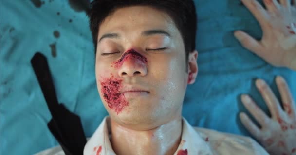 Gros plan du gars asiatique avec des blessures à la tête couché sur stratcher médical en ambulance. Jeune homme avec blessure et sang sur la tête qui perd conscience en allant à l'hôpital après un accident. — Video