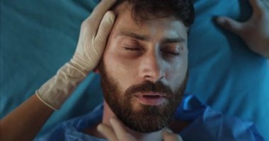 Hasta sakallı adamın kalp atışı tıbbi sedyede yatarken durdu. 30 'lu yaşlarda bir adam ambulansla hastaneye giderken ölüyor. Hastalık ve sağlık sigortası kavramı.