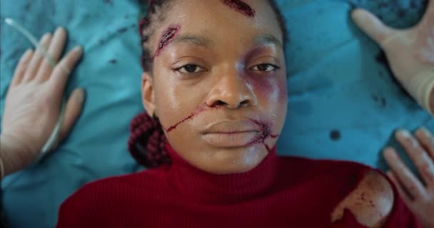Sanitäter kontrollieren die Herzfrequenz und setzen der jungen Frau eine Sauerstoffmaske auf. Draufsicht eines afroamerikanischen Mädchens mit Kopfverletzungen, das im Krankenwagen auf einer Krankentrage liegt. — Stockvideo