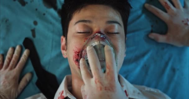 Bovenaanzicht van dokters handen die gewond jonge man zuurstof inhalatie masker afdoen. close-up van bewusteloze aziatische man sterven terwijl liggend op medisch vervoer kar op weg naar het ziekenhuis. — Stockvideo