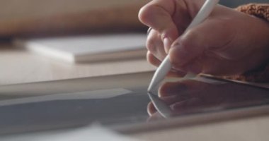 Tablet 'te resim yaparken stil kullanan kadın grafik tasarımcısının görüntüsünü kapat. Kadın eli iş yerinde dijital illüstrasyon yaratıyor. Yaratıcılık kavramı.