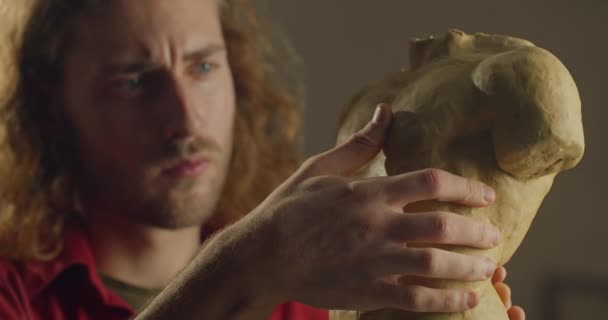 Jeune beau sculpteur travaillant sur le torse humain de l'argile de poterie. Sérieux homme millénaire création de sculpture dans l'atelier d'artiste.Concept d'œuvres d'art artisanales et de créativité. — Video