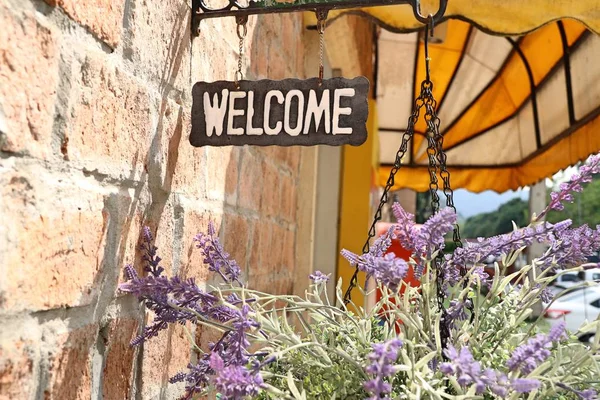 Signo Bienvenida Con Flores Artificiales —  Fotos de Stock