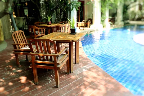 Mesa e cadeiras à beira da piscina — Fotografia de Stock