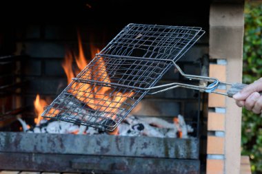 Barbekü alevler içinde, dışarıda ızgara yapmaya hazır. Bahçede ye..