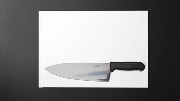 Cuchillo Afilado Sobre Papel Blanco Sobre Fondo Negro Stock Fotografía —  Fotos de Stock